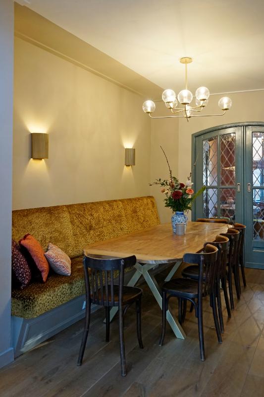 Eethoek met een maatwerk eetkamerbank in het geel gestoffeerd.