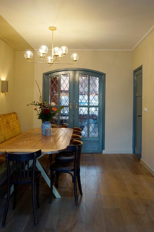 Eethoek met een maatwerk eetkamerbank in het geel gestoffeerd. Met blauw geschilderde deuren.