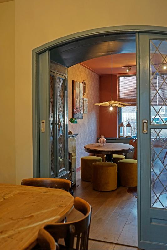 Doorkijk naar tafel met poefen.