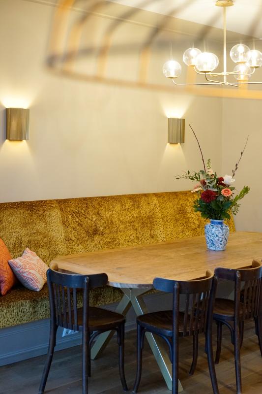 Eethoek met een geel gestoffeerde maatwerk eetkamerbank.