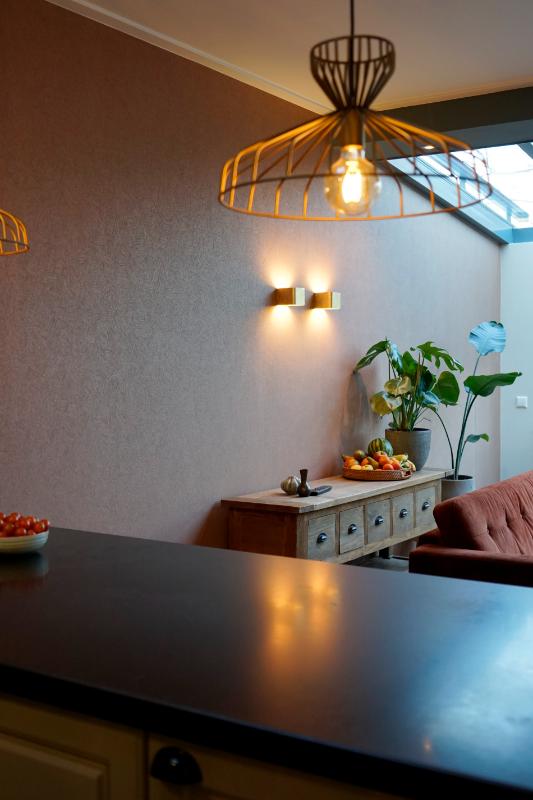 Doorkijk naar de woonkamer met twee wandlampen.