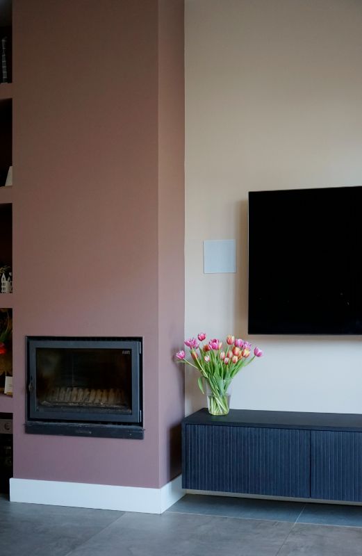 Haard met roze ombouw. Zwevend tv meubel met tulpen.