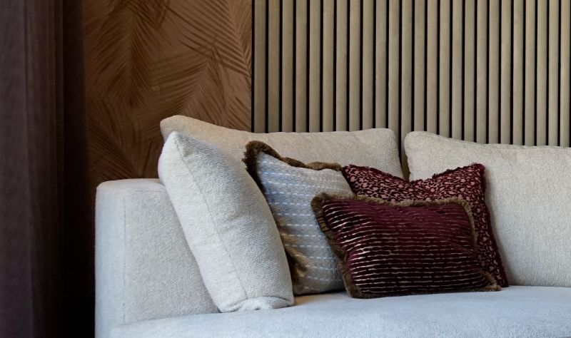 Lichte bank met bouclé stof. Mooie LOVI kussens. en akoestische panelen.