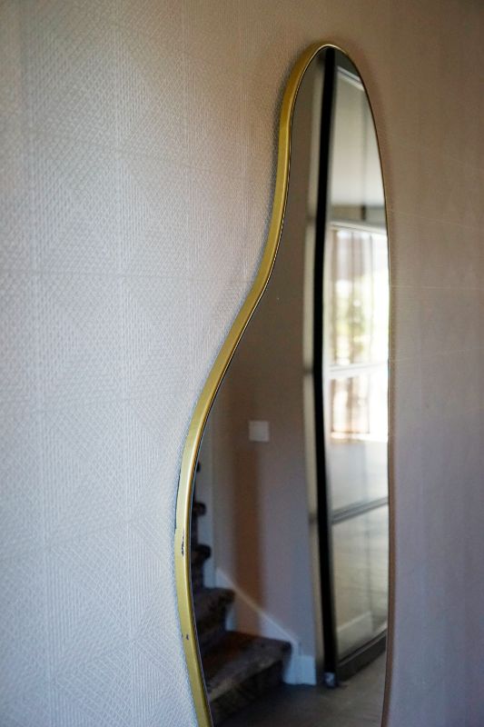 Behang met organische spiegel met een gouden rand.