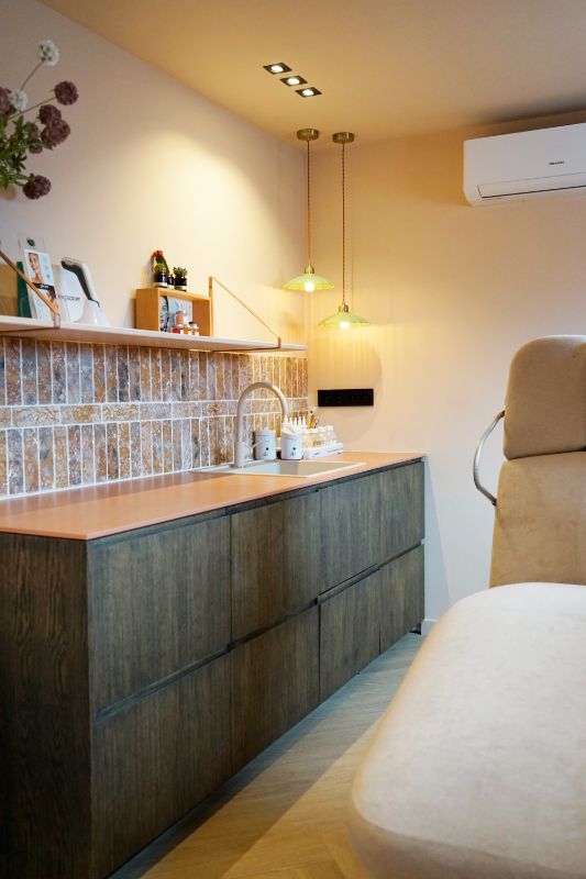Schoonheidssalon met een grote ligstoel en een keuken.