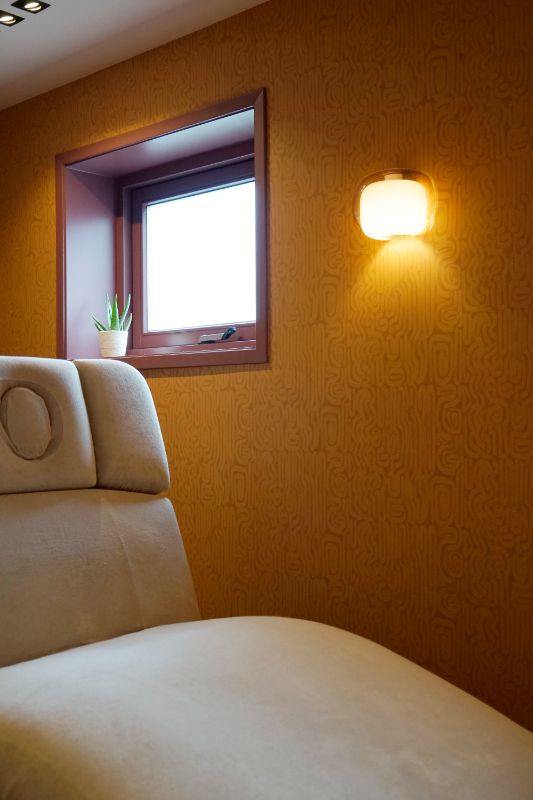 Ligstoel, schoonheidssalon, wandlamp met patroonbehang.