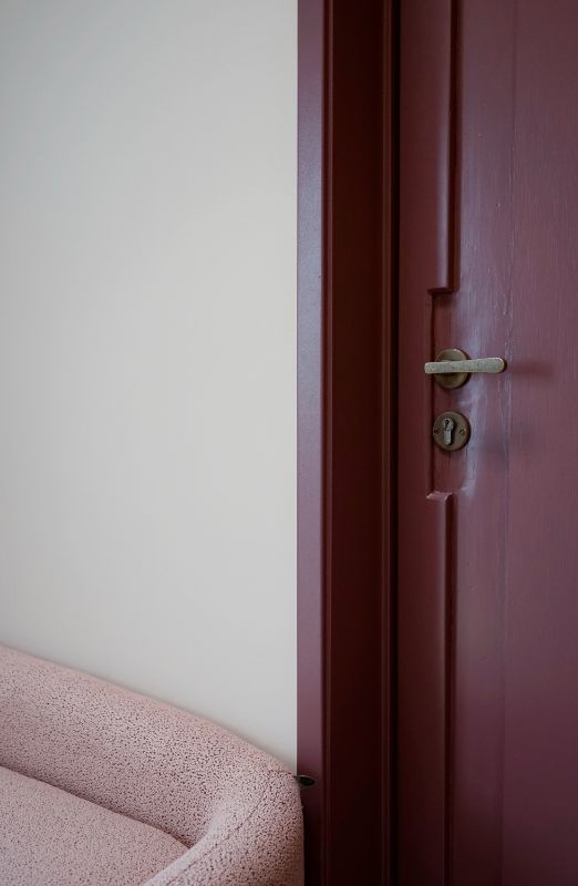 Burgundy deur met ruw brons deurbeslag.