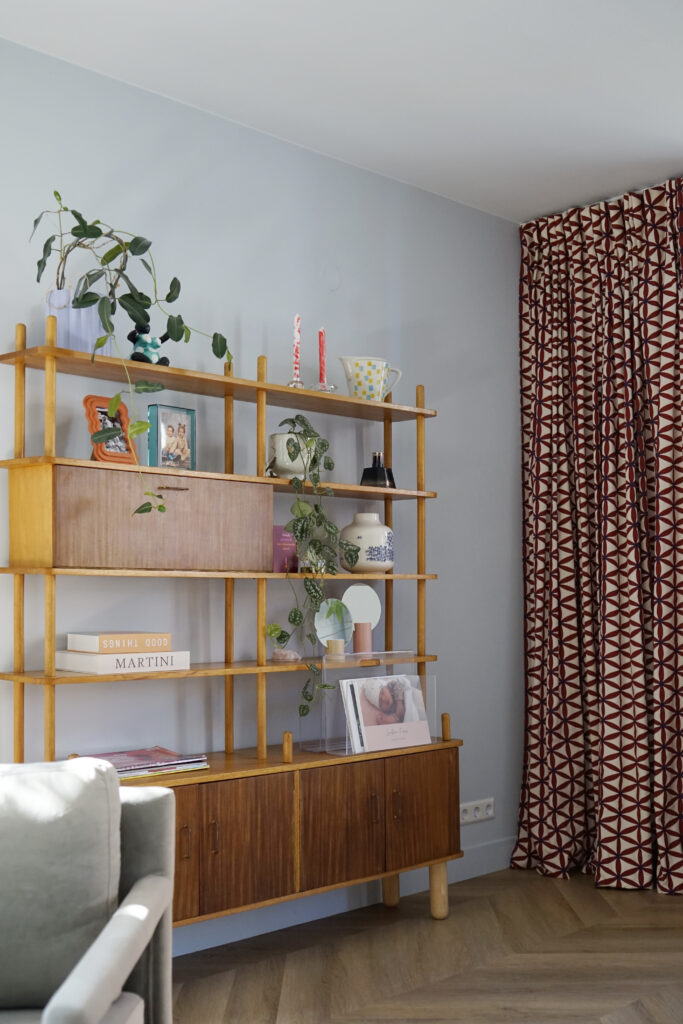 Vintage vakkenkast met gekleurde accessoires. Gordijnen met patroonstof.