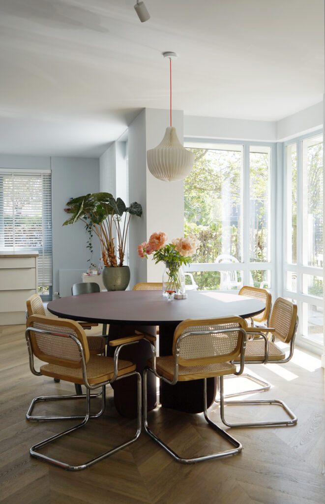 Bordeaux rode eettafel met rotan stoelen.