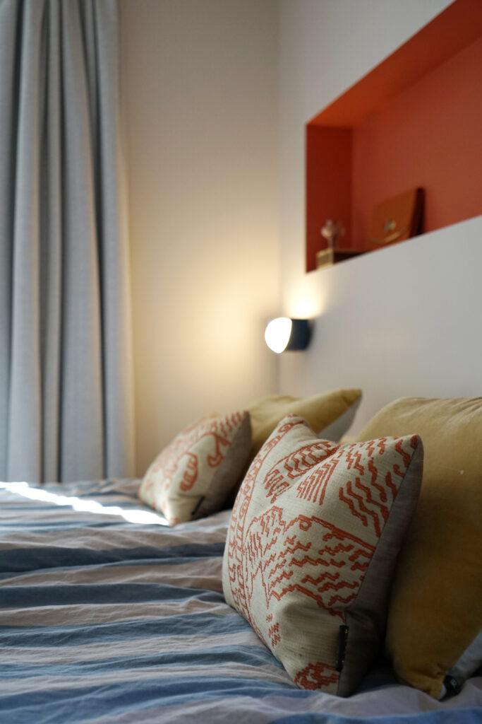 Slaapkamer met LOVI kussens op het bed.