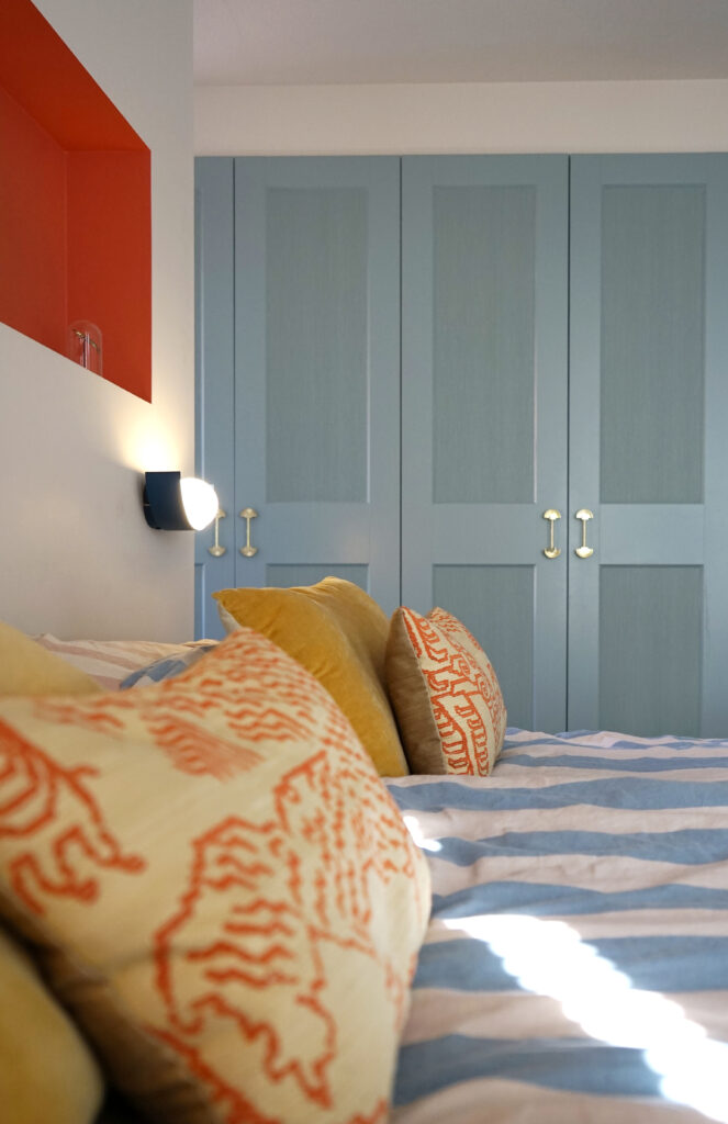 Slaapkamer met blauwe kledingkasten.