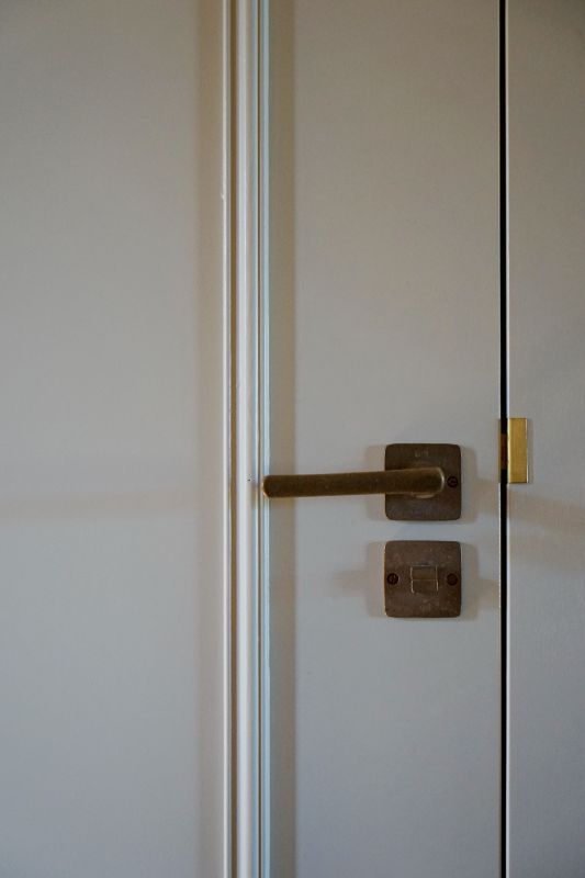 Deur met sierlijst en mooi ruw brons deurbeslag.