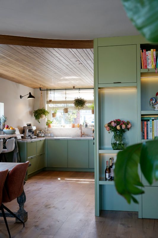Groene maatwerk keuken met organisch plafond.