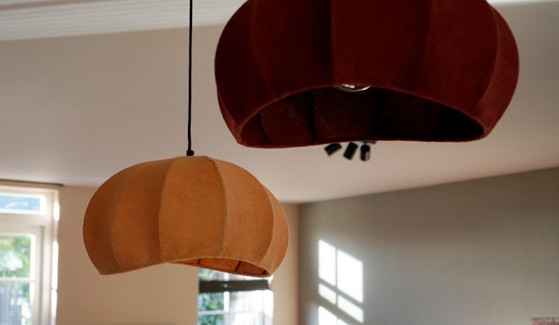 Gekleurde ballonlampen boven de eettafel.