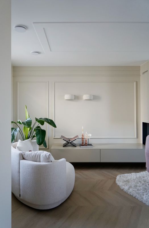 Lichte haardkamer met love seat. Wandlijsten met wandlampen.