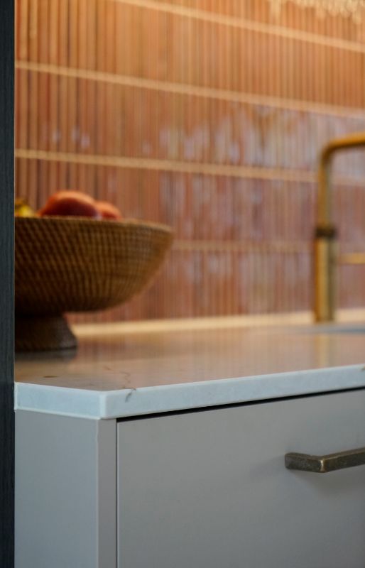 Warm beige keukenkasten met ruw bronzen greep.