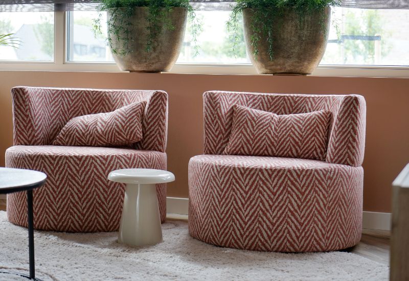Twee ronde fauteuils in een stof met v-patroon.